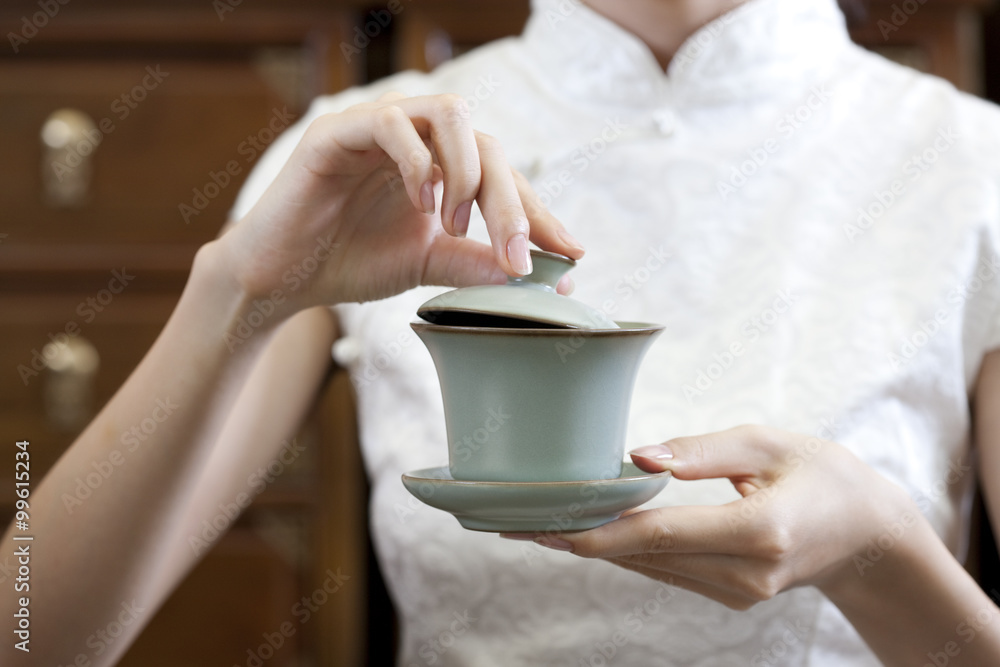年轻女子端着一杯中国茶