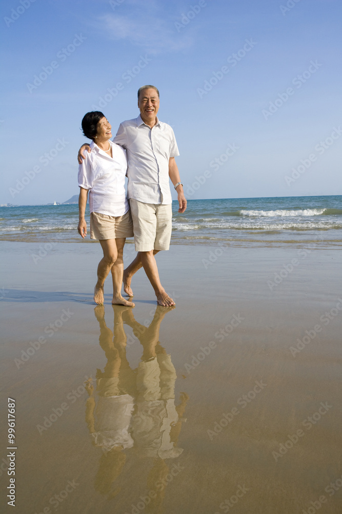 老年夫妇沿着海滩散步