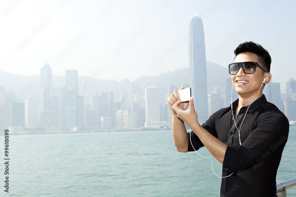 香港维多利亚港时尚年轻人用智能手机拍照