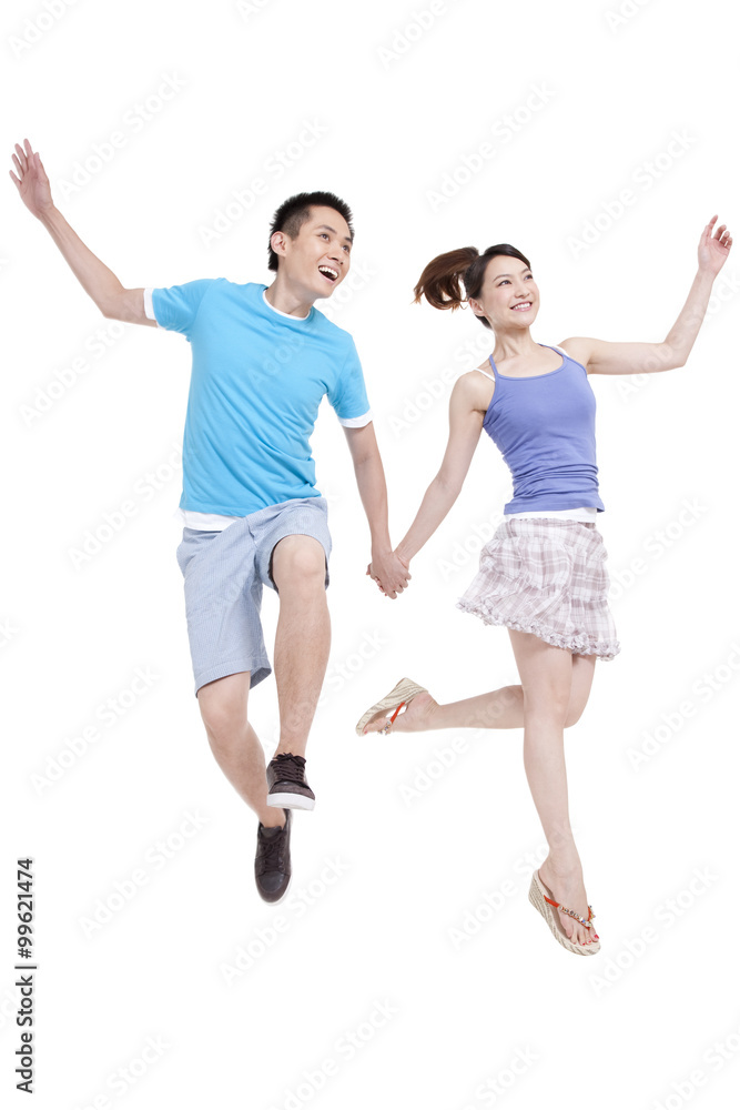 Excited young couple jumping in mid air