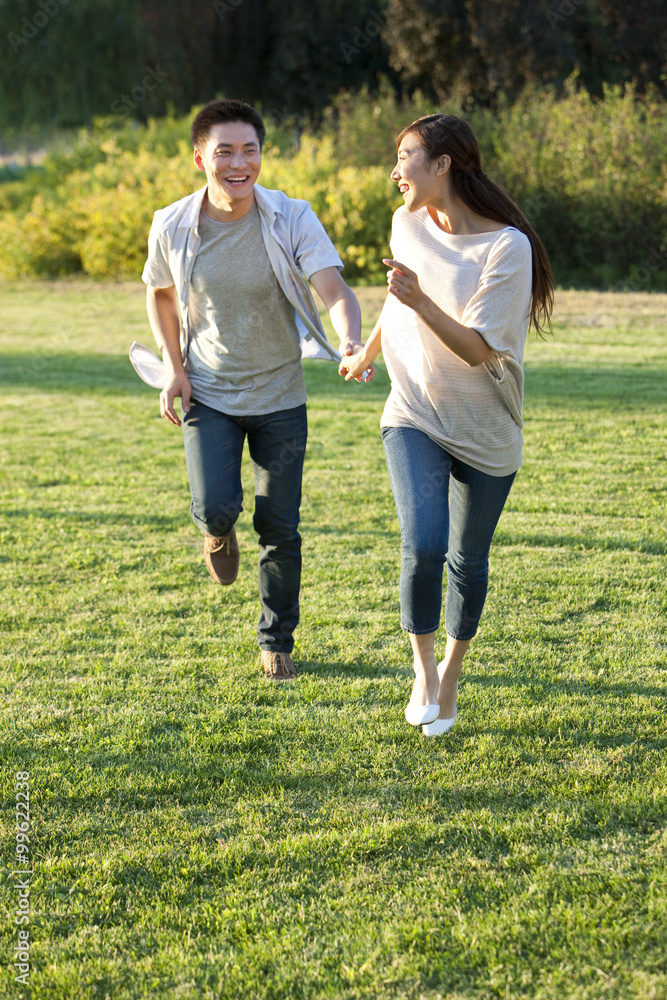 年轻的中国夫妇在公园里跑步