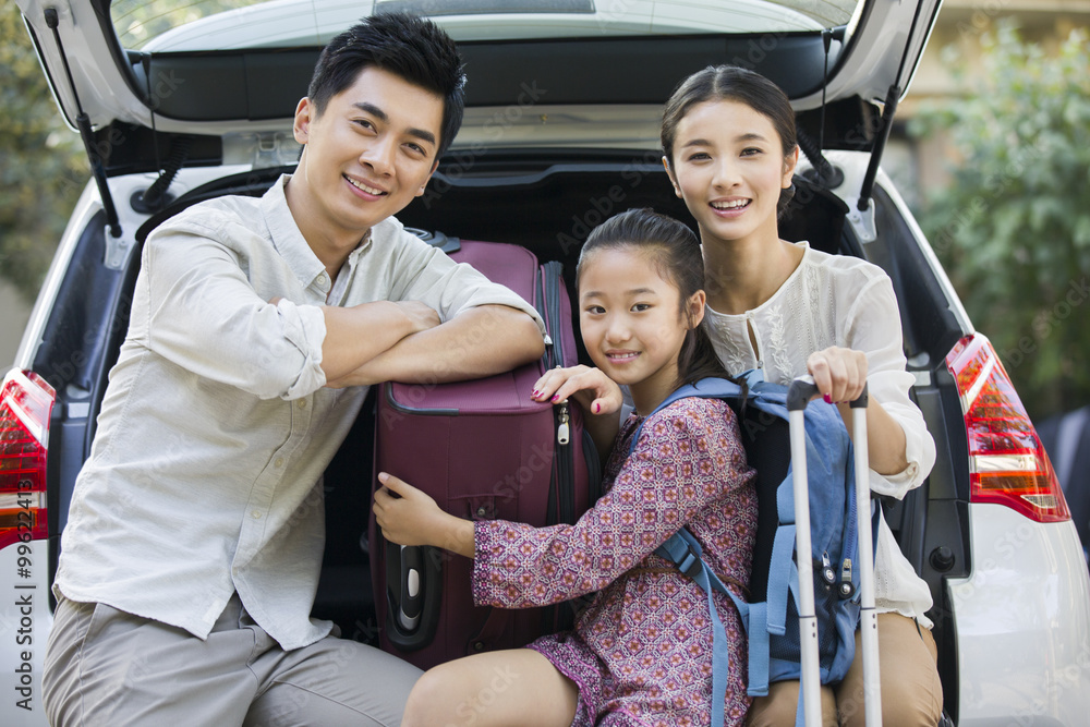 年轻的家庭为汽车旅行打包