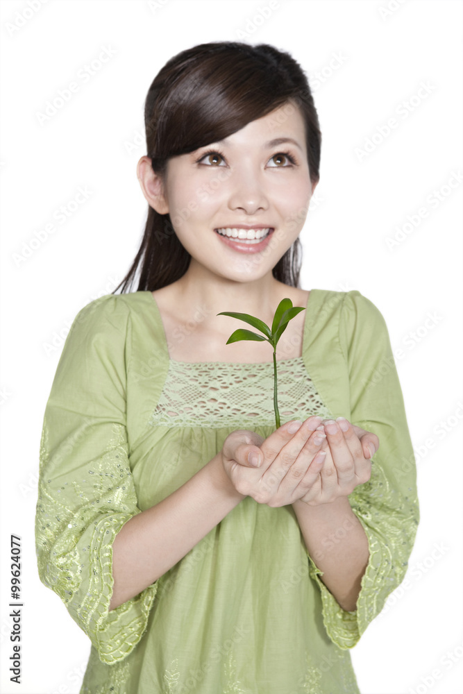 Portrait of Young Woman Holding Seedling
