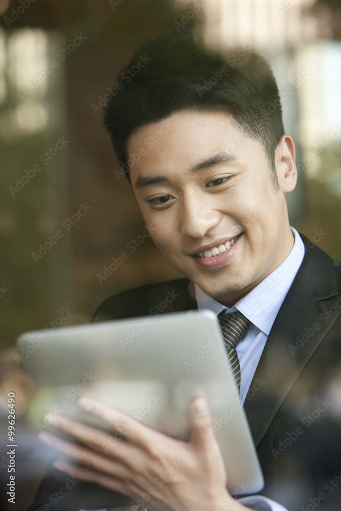 商人在咖啡馆玩数字平板电脑