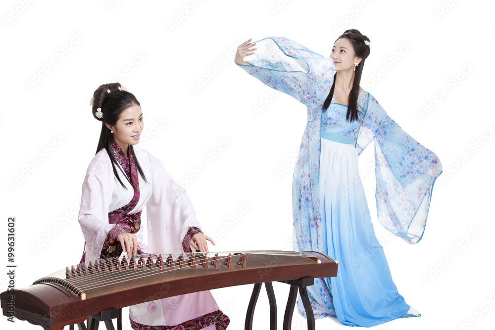 身穿中国传统服装的年轻女性弹起古筝跳舞