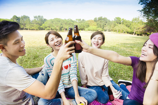快乐的年轻朋友享受野餐和喝啤酒