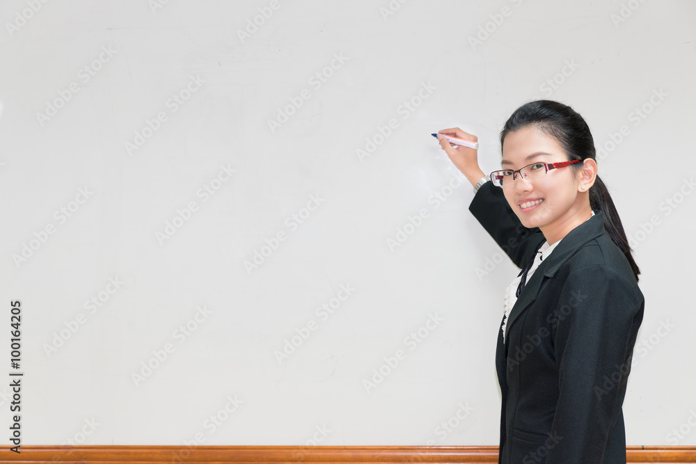 亚洲女人用钢笔在白板上写东西并解释