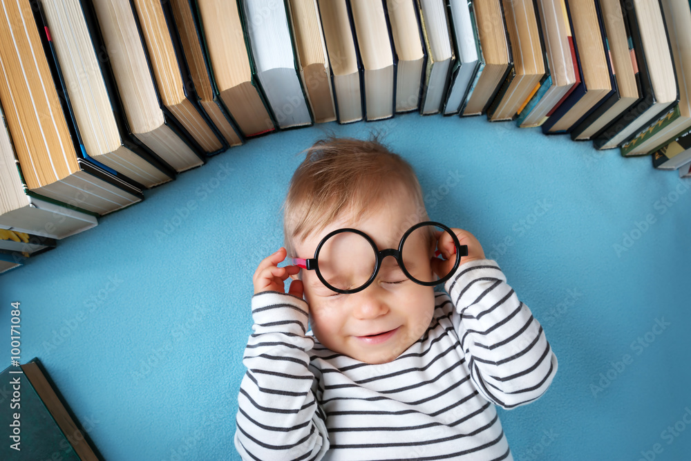 带眼镜和书的一岁婴儿