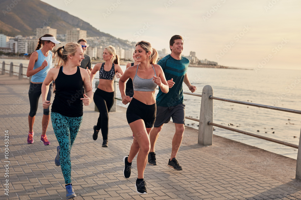 一群运动员沿着海滨长廊奔跑