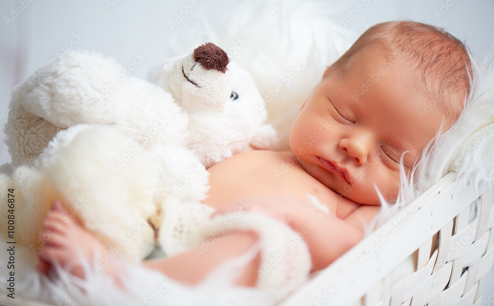 可爱的新生儿和玩具泰迪熊睡觉