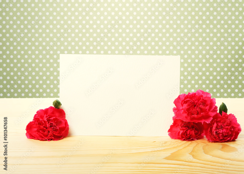 桌上有康乃馨花的空白贺卡