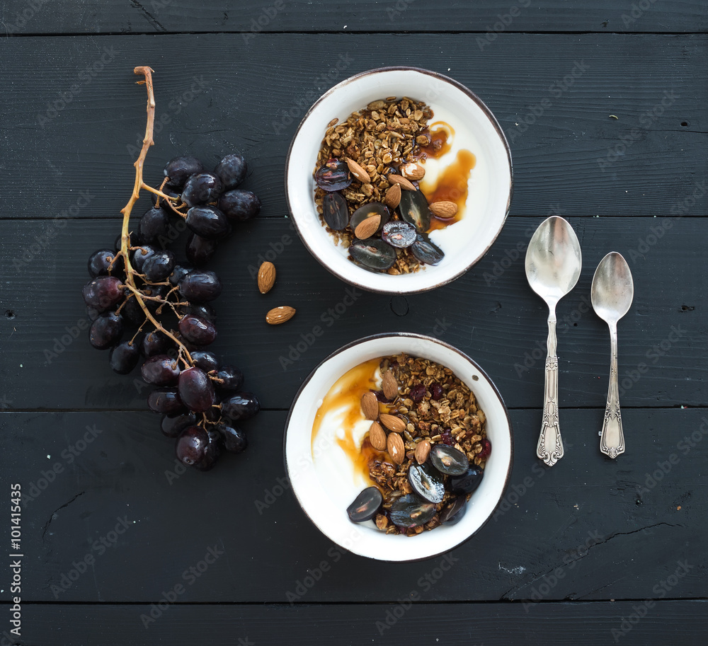 健康早餐套装。一碗燕麦格兰诺拉麦片配酸奶、新鲜葡萄、杏仁和蜂蜜。