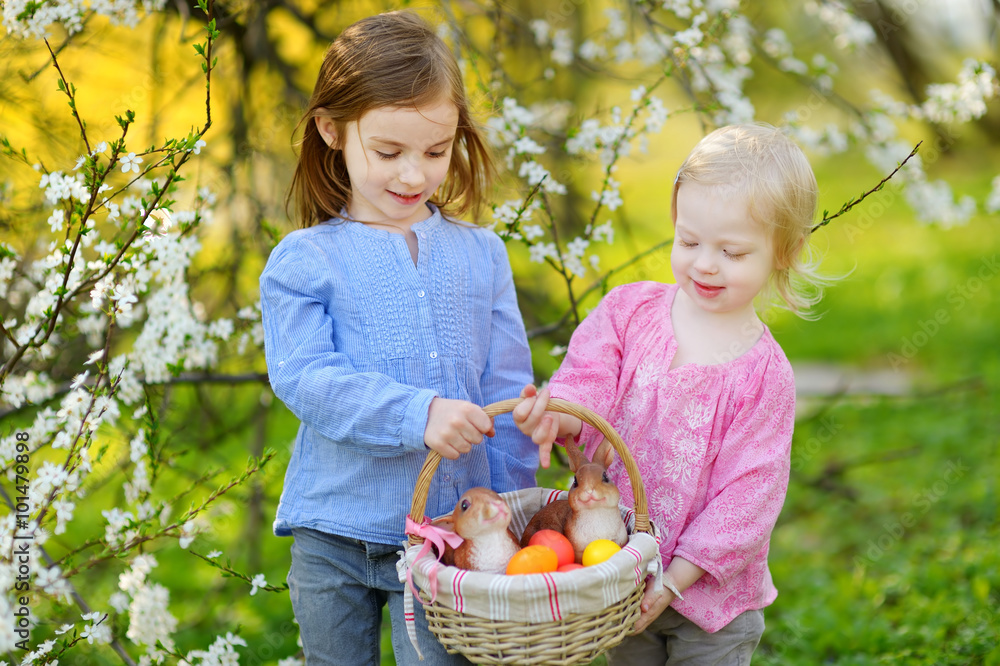 复活节那天，两个小姐妹拿着一篮子复活节彩蛋