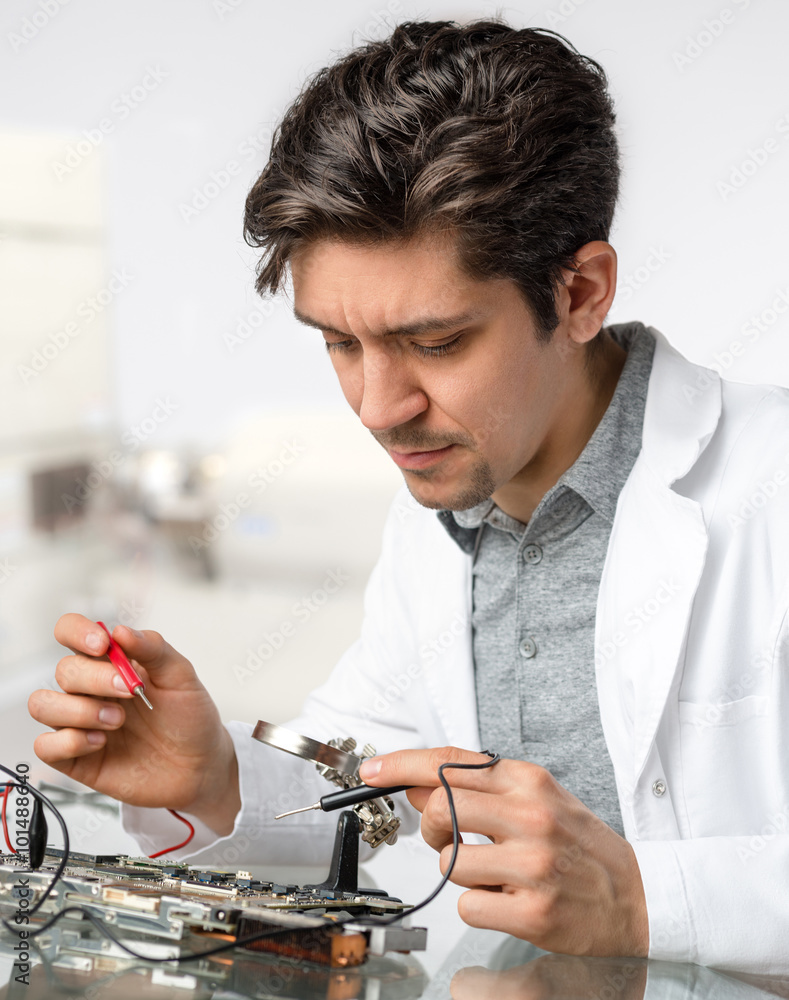 年轻精力充沛的男性技术人员或工程师维修电子设备