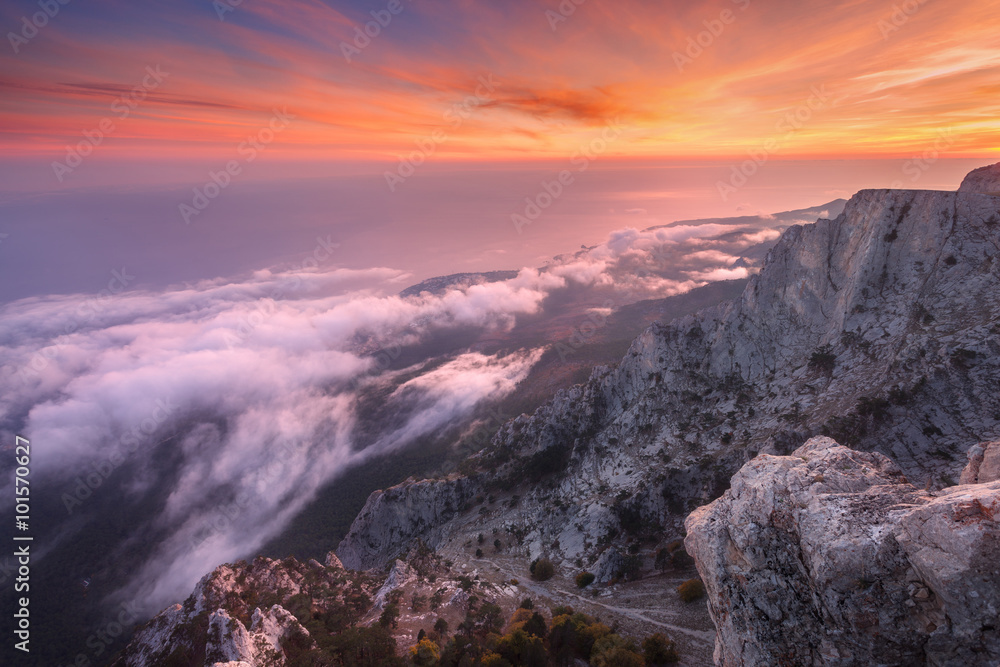 Beautiful landscape on the top of mountains with sea, colorful sunset and low clouds. Nature backgro