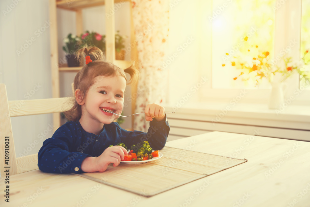 快乐的小女孩吃着蔬菜笑着