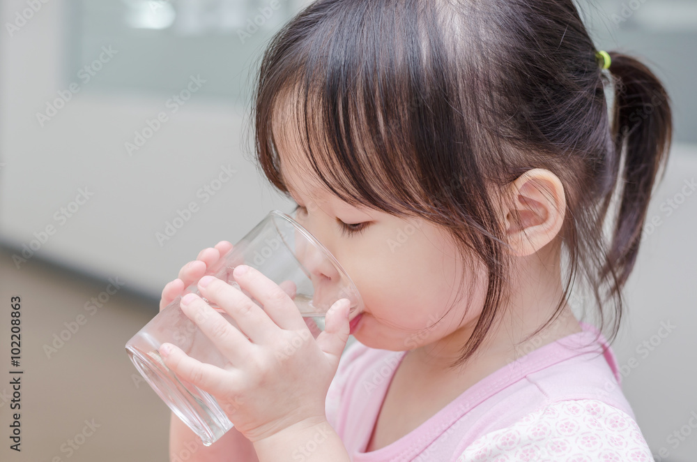 亚洲小女孩用玻璃喝水