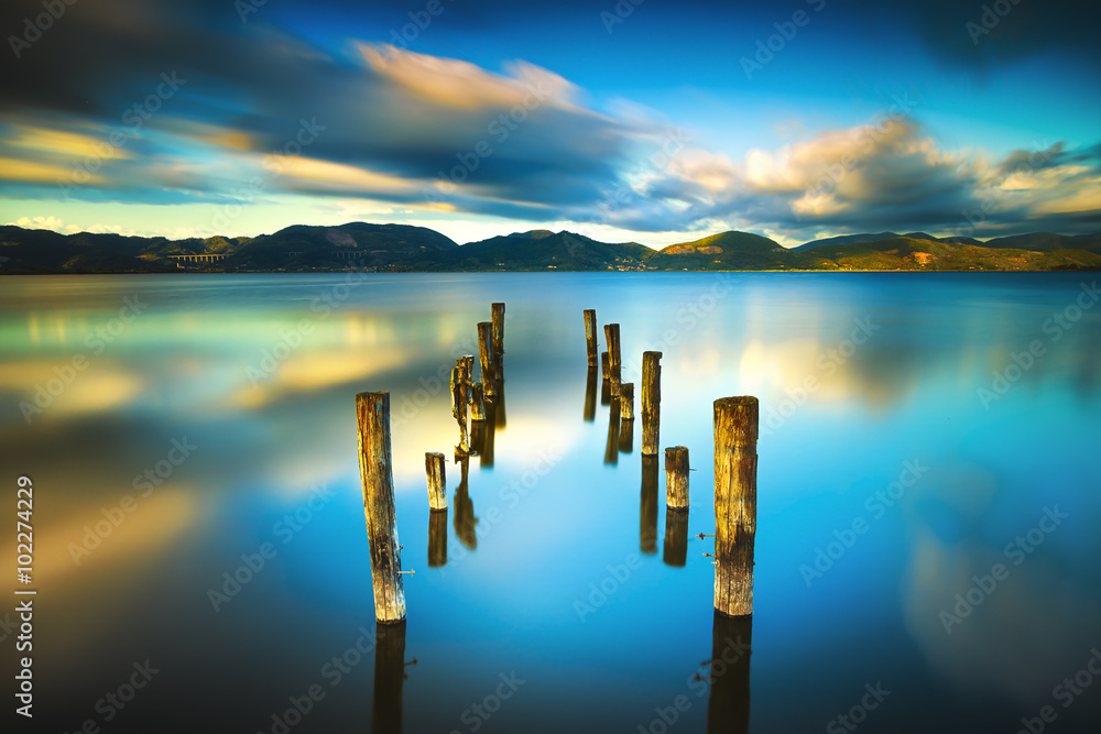 木制码头或码头保留在蓝色的湖面上，日落和天空反射