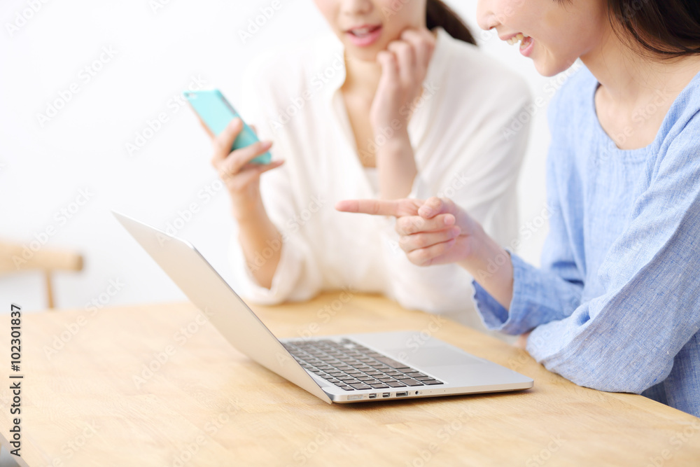ノートパソコンを使う二人の若い女性