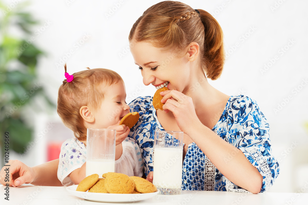 幸福的家庭母亲和宝贝女儿在早餐：饼干
