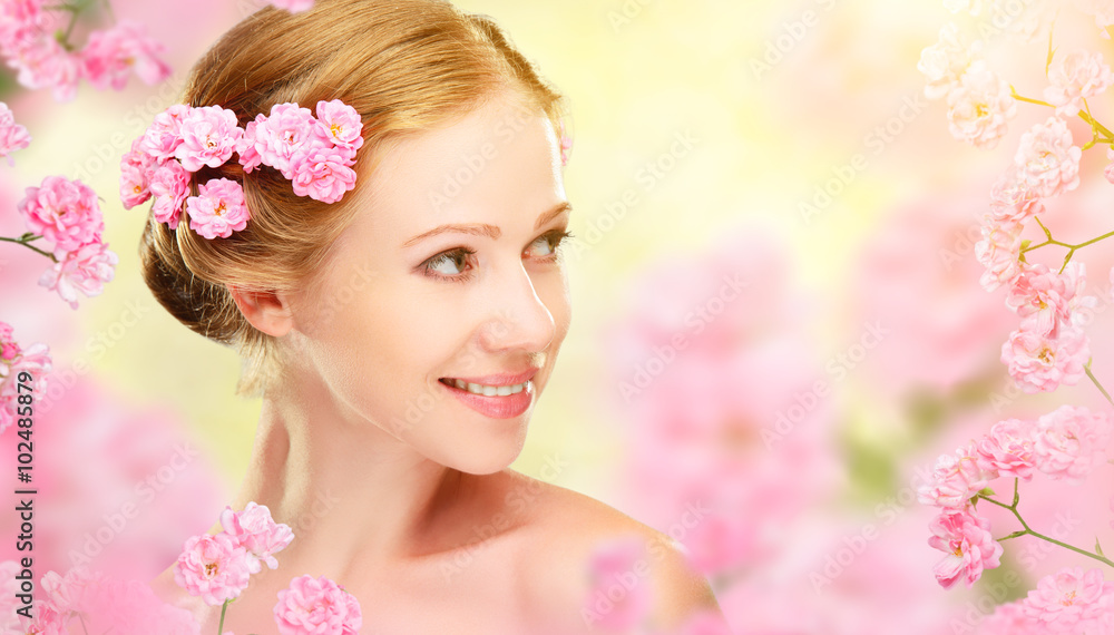 年轻美女的美丽面孔，她的ha里有粉色的花朵