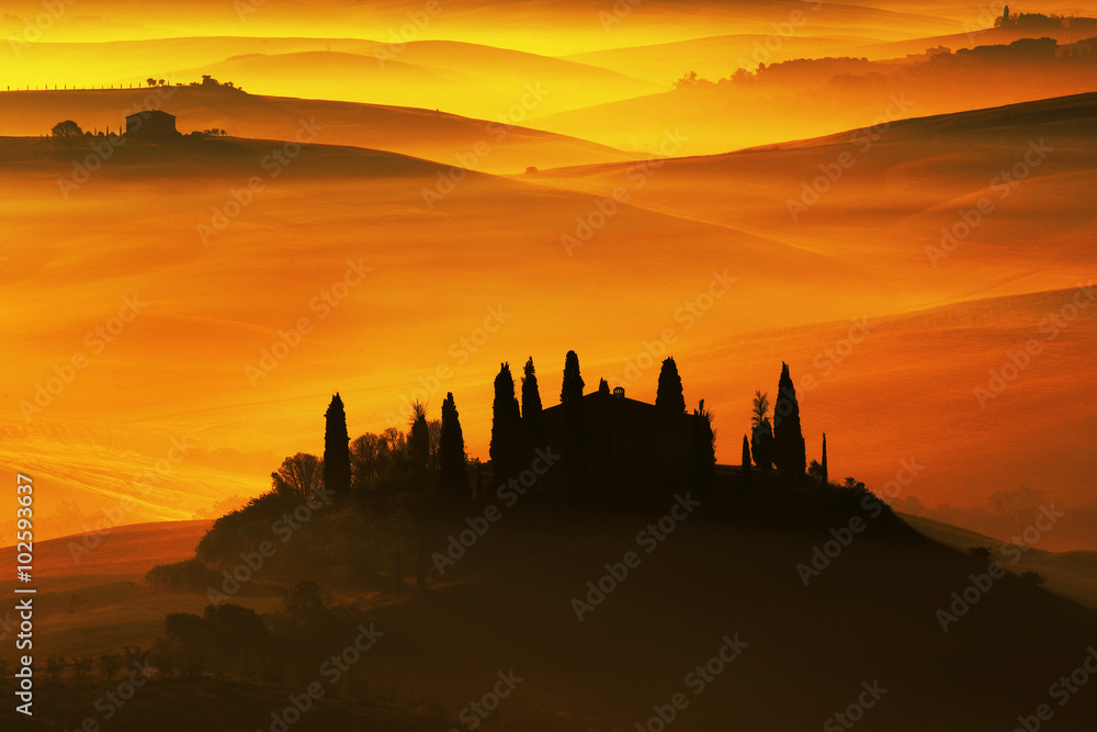 意大利典型的托斯卡纳风景，橙色日落时的山丘房屋