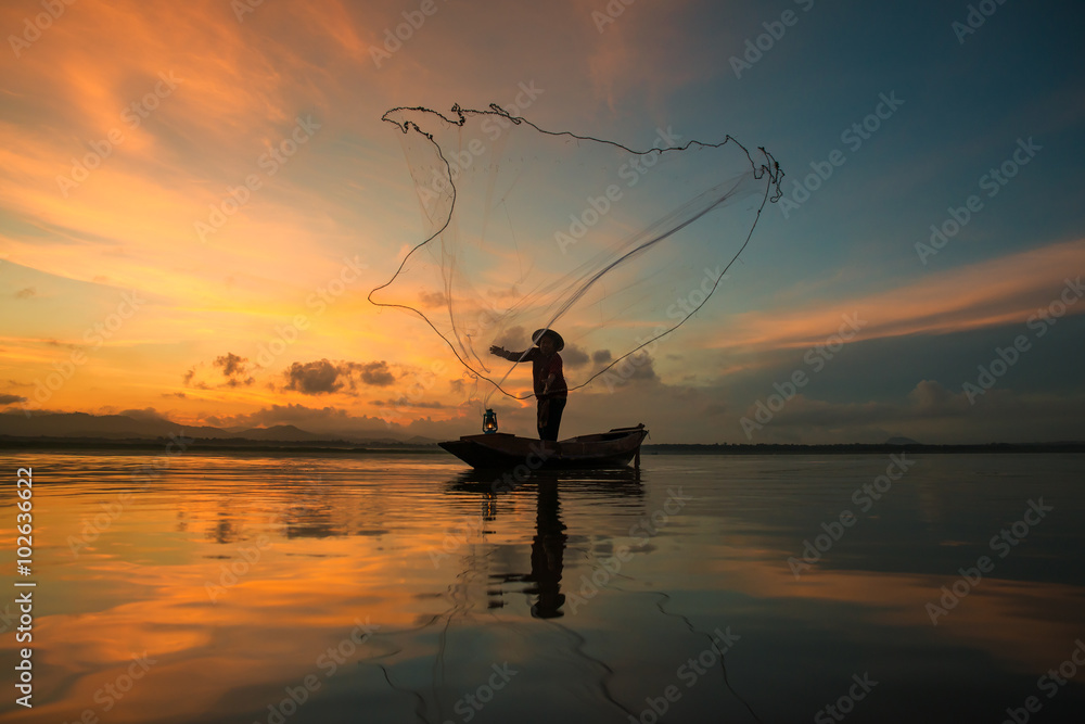 泰国早晨，渔民在湖边捕鱼。