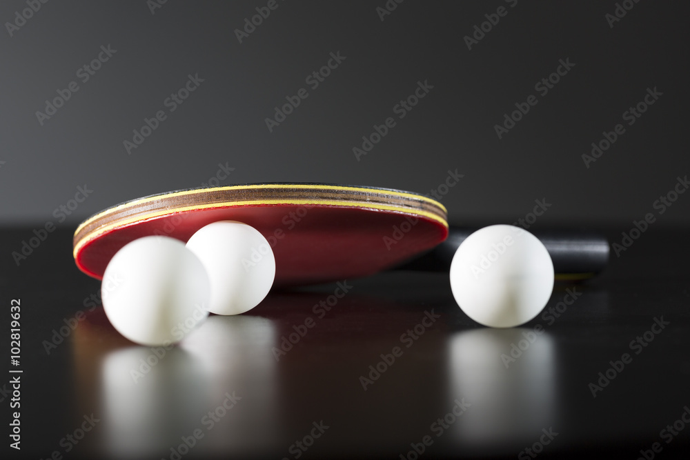 深色桌子上的乒乓球拍和球