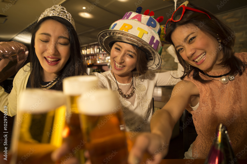 Three women are doing a birthday party in a bar