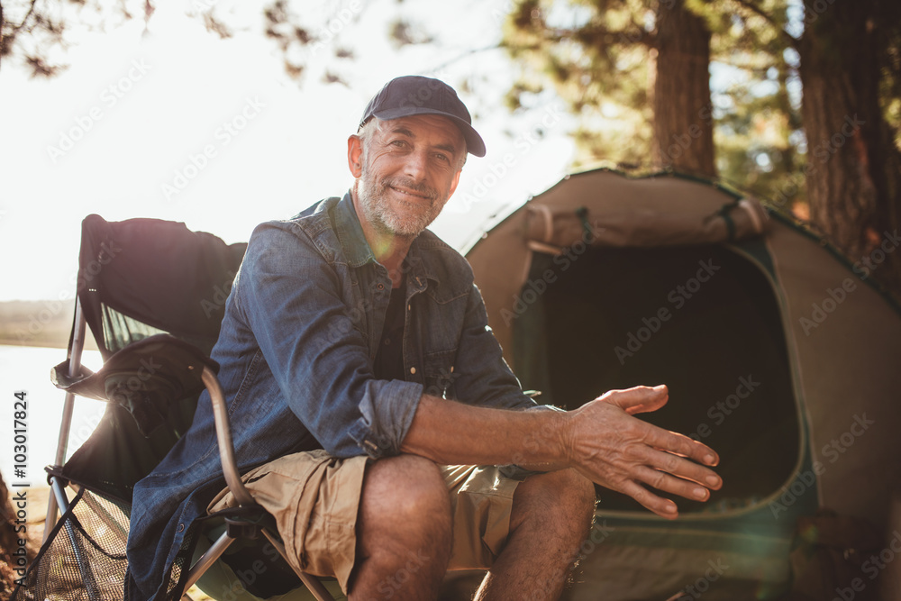 快乐的成熟男人坐在帐篷前