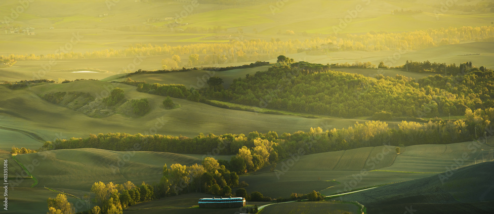 意大利托斯卡纳日落时分的波涛汹涌的田野。自然的户外季节性春天背景。全景。