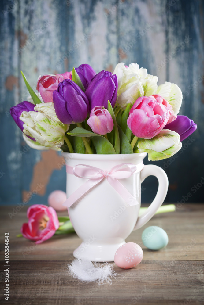Beautiful tulips bouquet and easter eggs  on wooden table