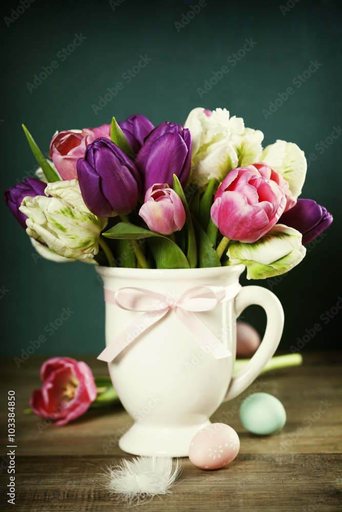 美丽的郁金香花束和木桌上的复活节彩蛋