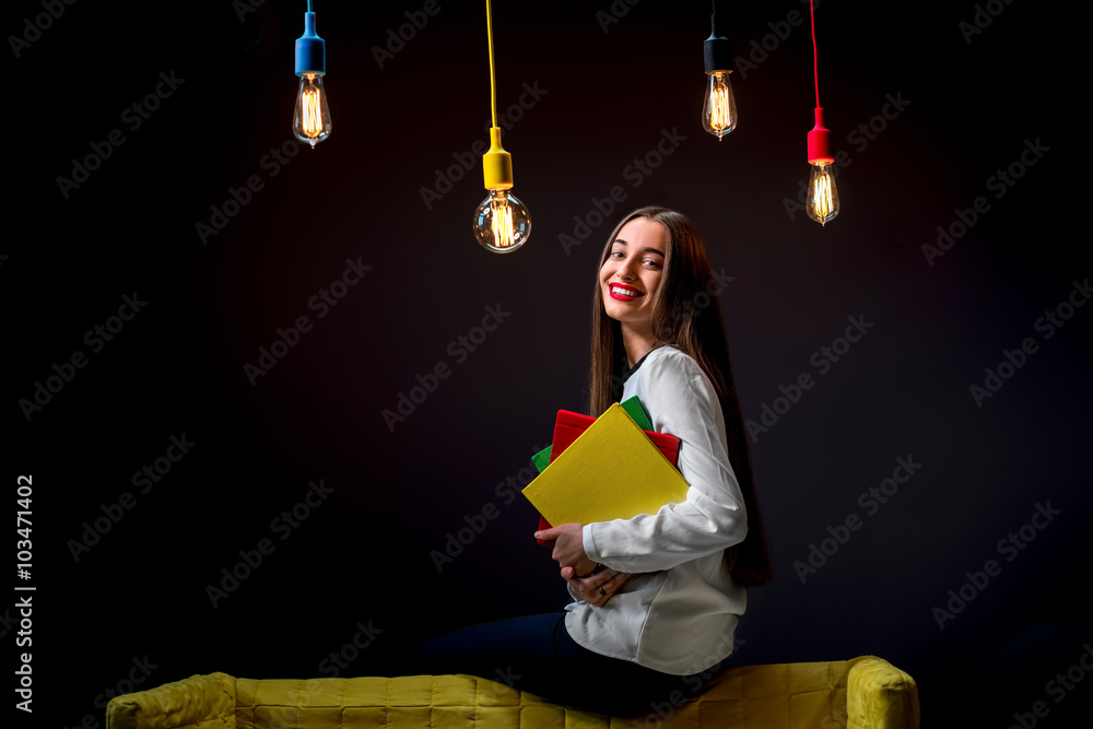 Young creative student with colorful lamps and books