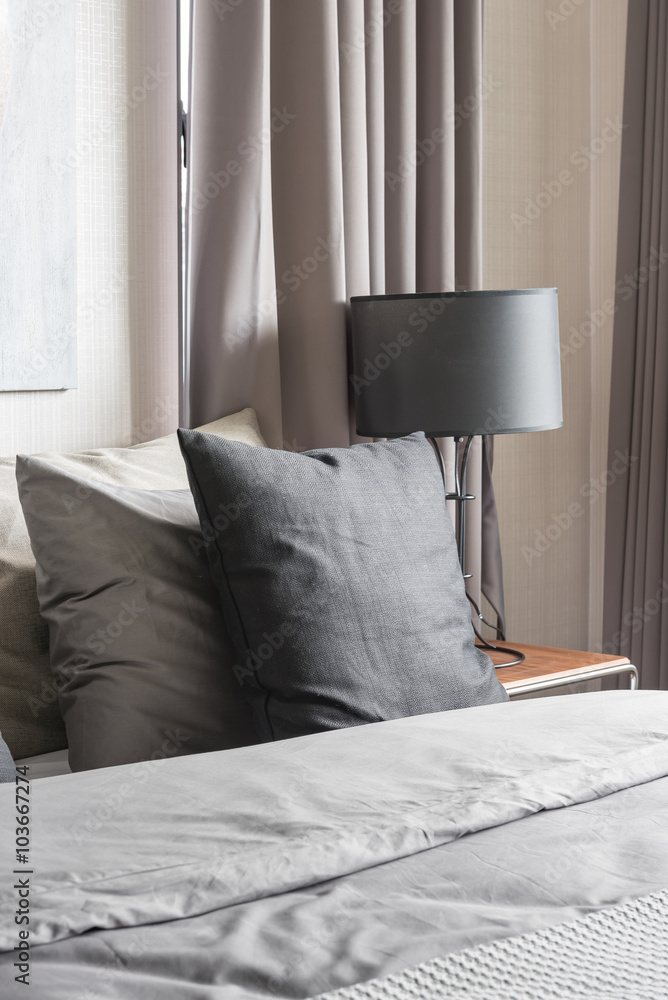 黑色灯现代卧室白色床上的灰色枕头