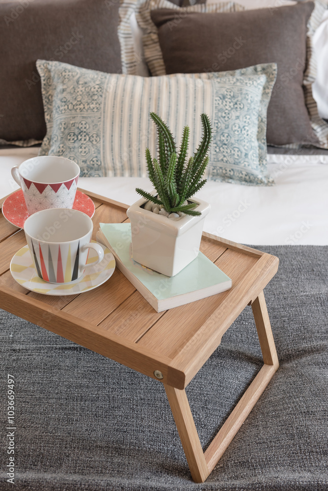 现代卧室木托盘上的一瓶植物和一杯咖啡