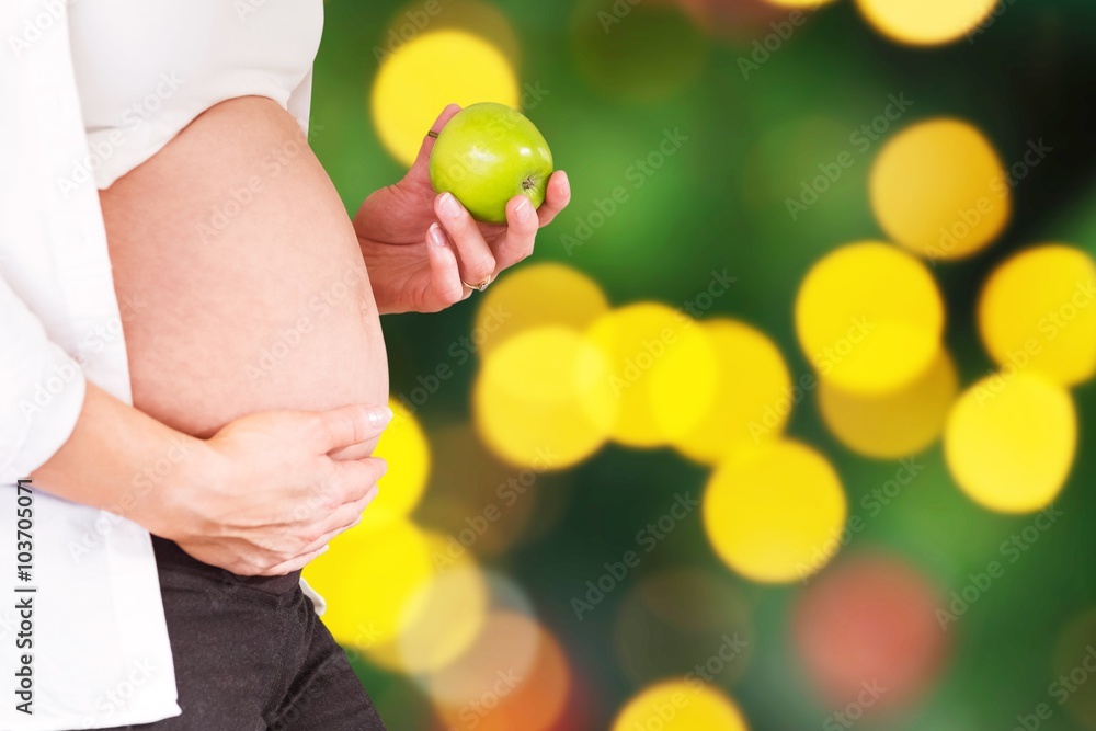 孕妇抱着青苹果的腹部合成图
