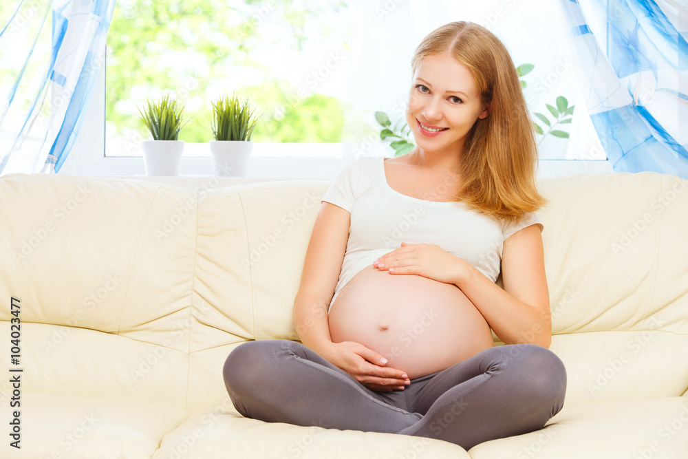 幸福的孕妇在家沙发上休息