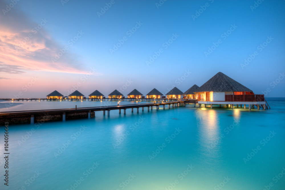 日落时分马尔代夫度假岛上的水上别墅
