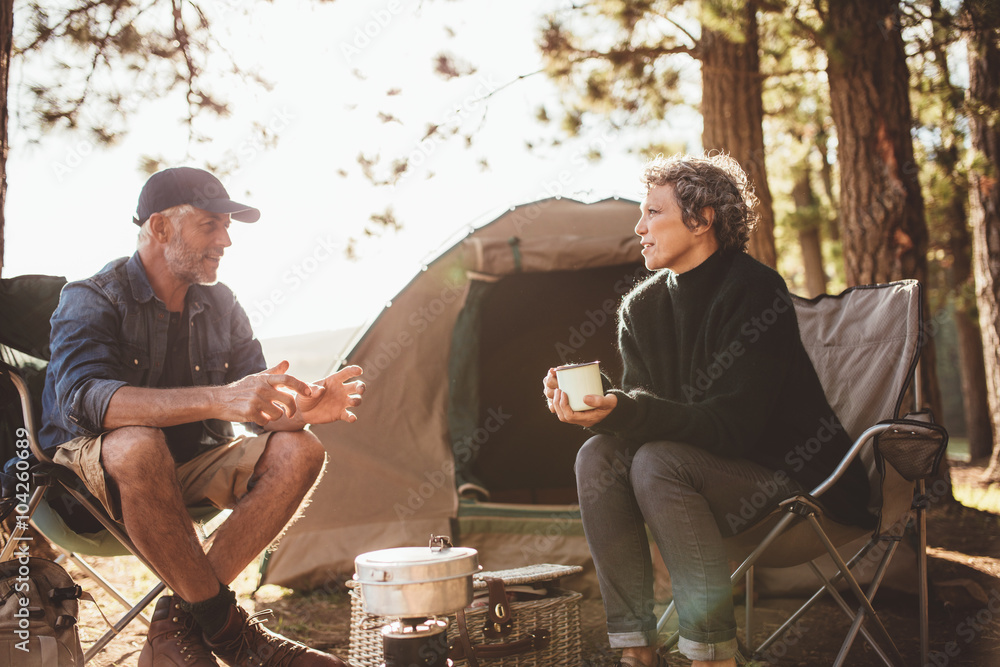 成熟的男人和女人在露营地坐着聊天
