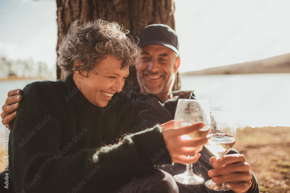 放松的成熟夫妇在露营地喝了一杯葡萄酒