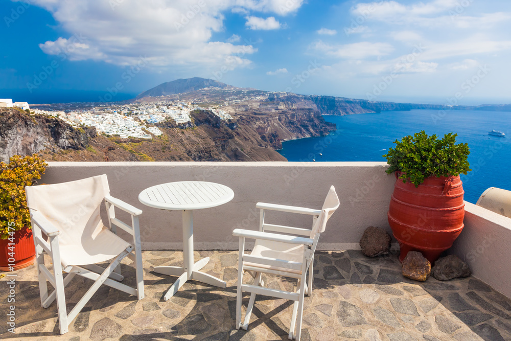 希腊圣托里尼岛屋顶上的桌子和椅子，可欣赏全景。