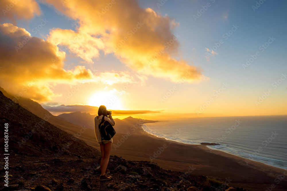 科菲特海岸线美丽的海景，年轻的女性旅行者在富特文图拉日落