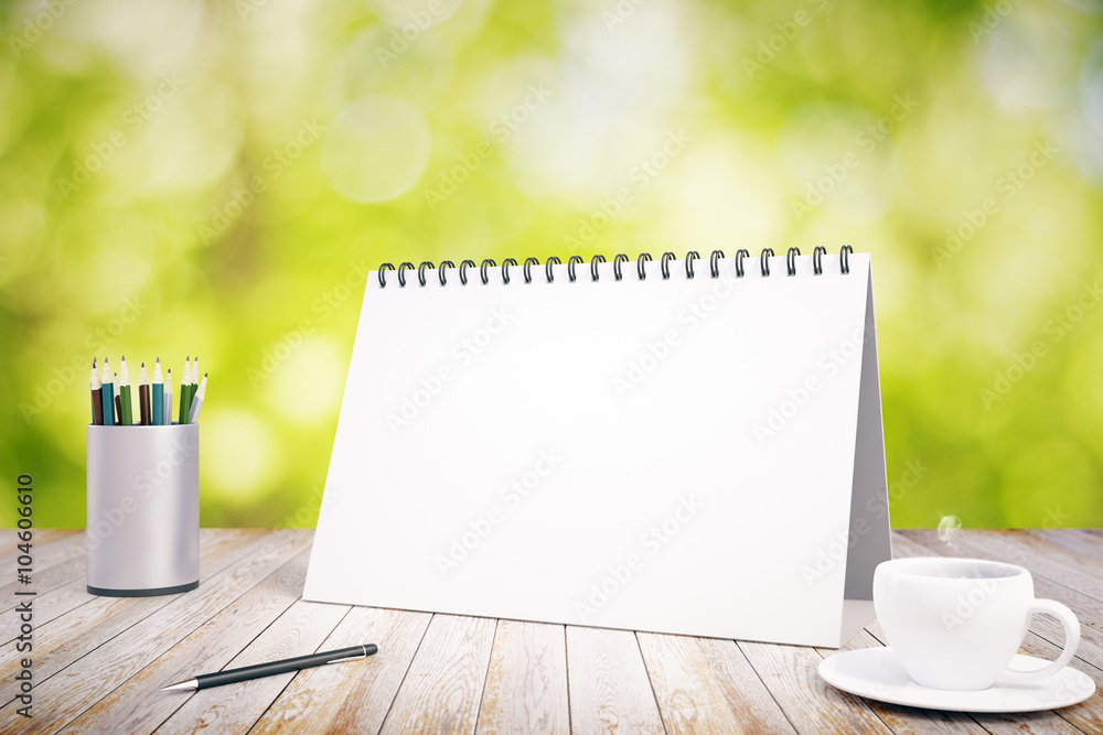 木制桌子上的空白日记封面，上面有铅笔和一杯咖啡