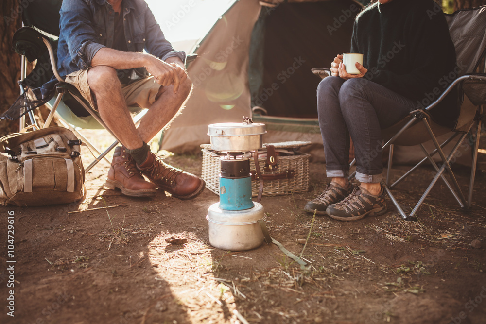 一对成熟的情侣坐在露营地的露营火炉旁