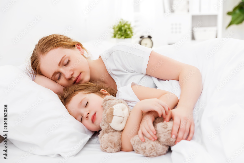 幸福的家庭母亲和孩子睡在床上