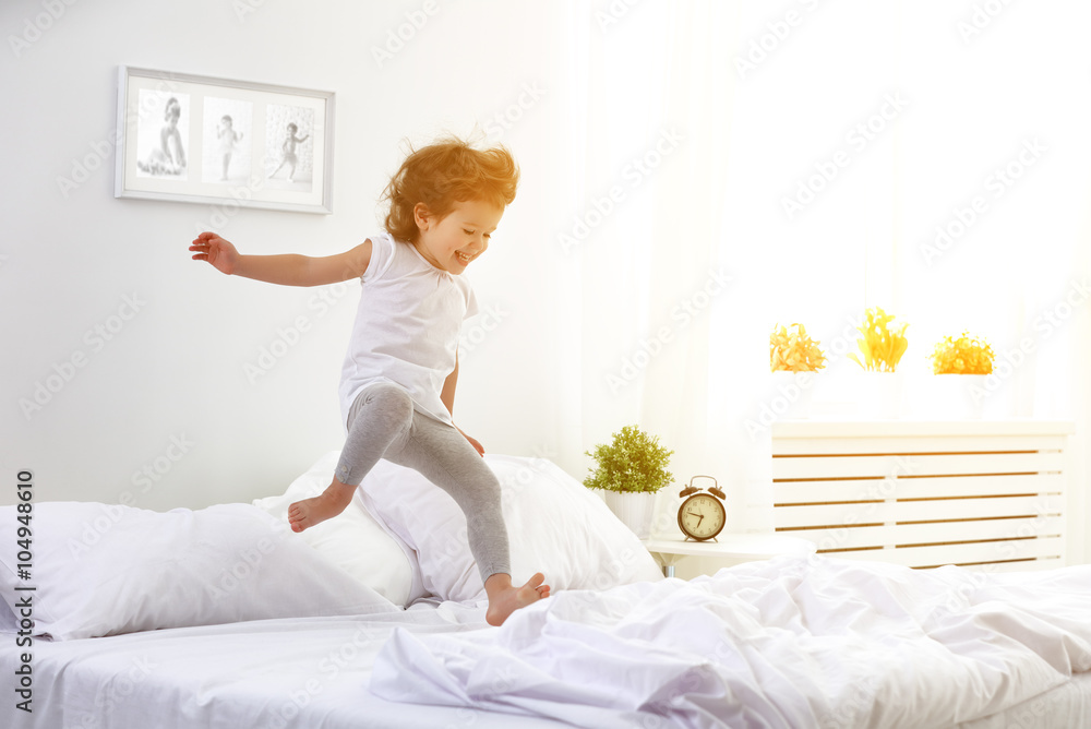 快乐的小女孩跳起来玩床