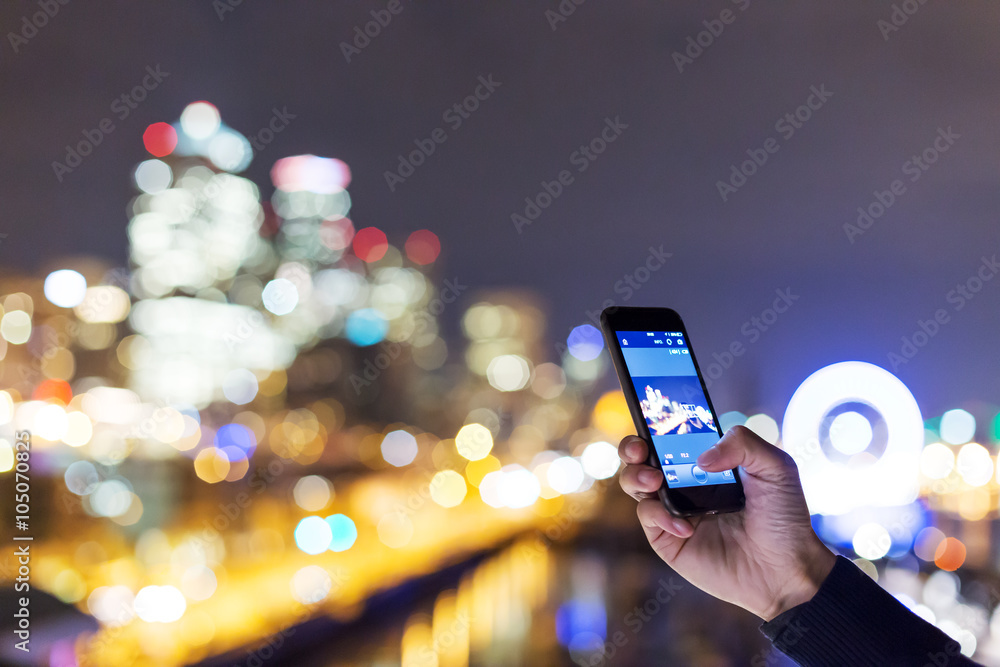 smartphone with cityscape and night scene of seattle