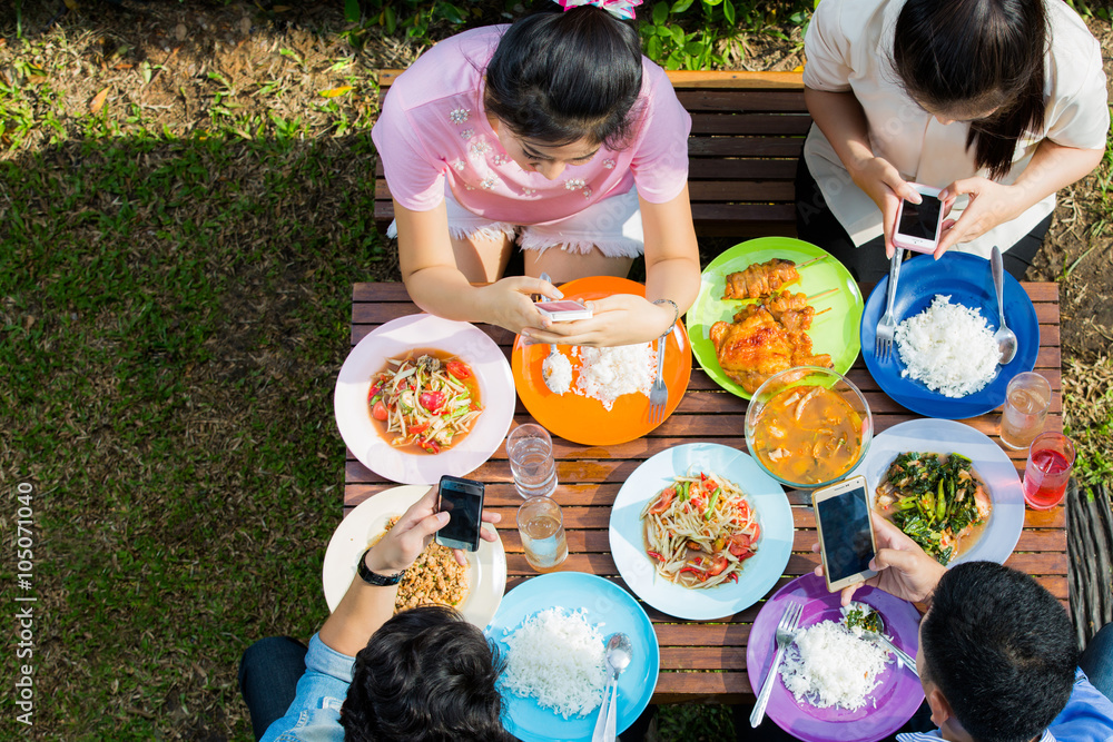 Asian eat on vacation, everyone picks up the phone to use while eating