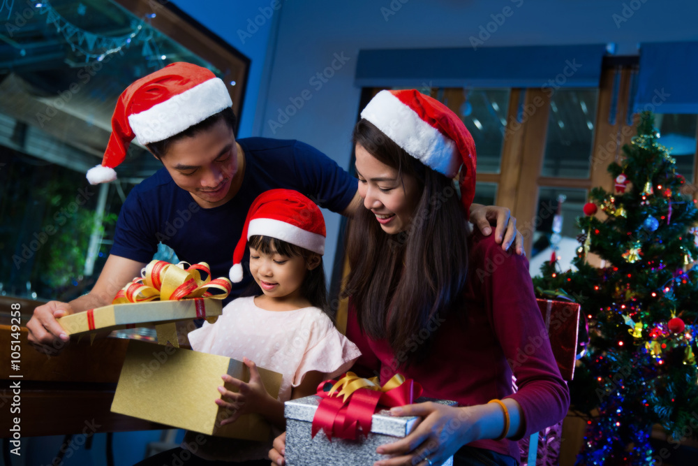 亚洲家庭在圣诞节快乐地打开礼盒